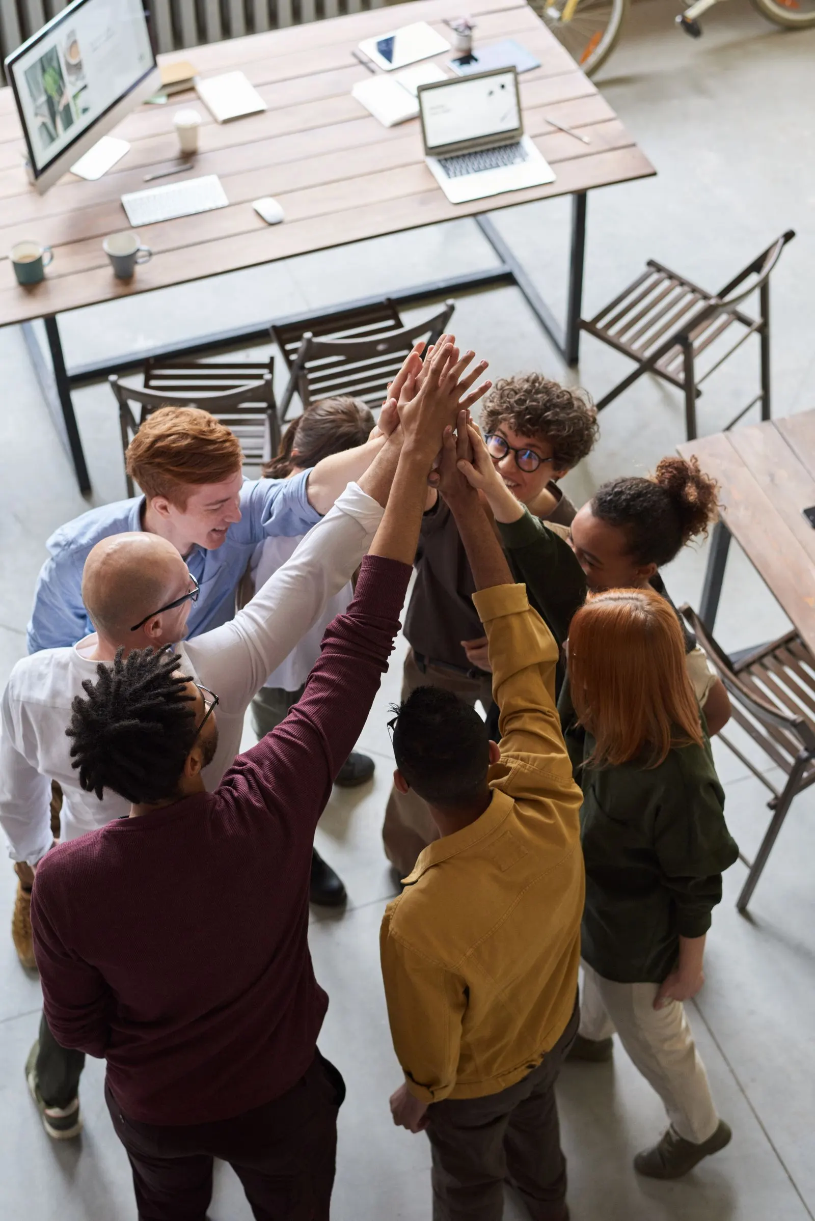Group of colleagues high-fiving in a bright office