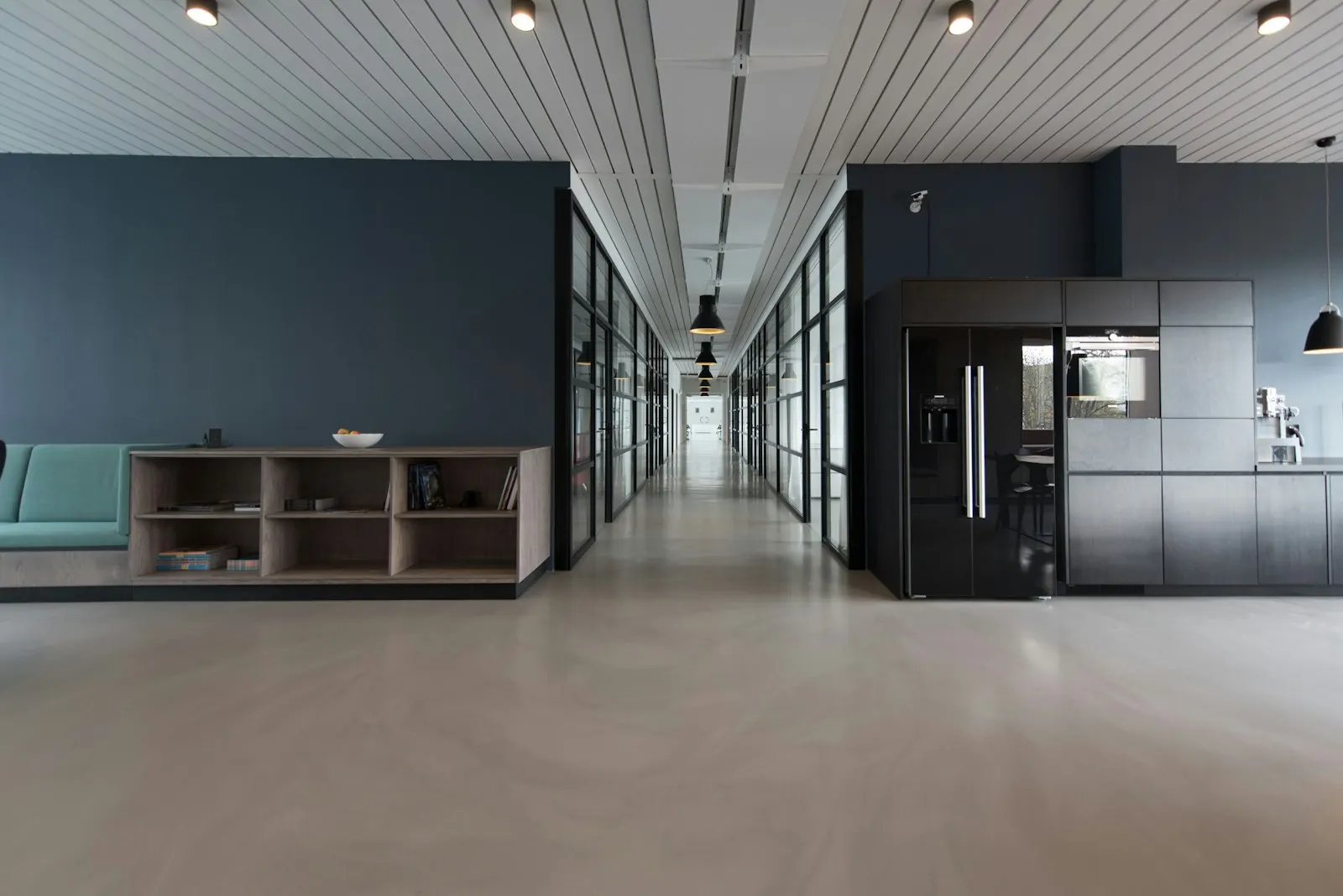Sunlit modern office with white desks, wood chairs, and large windows