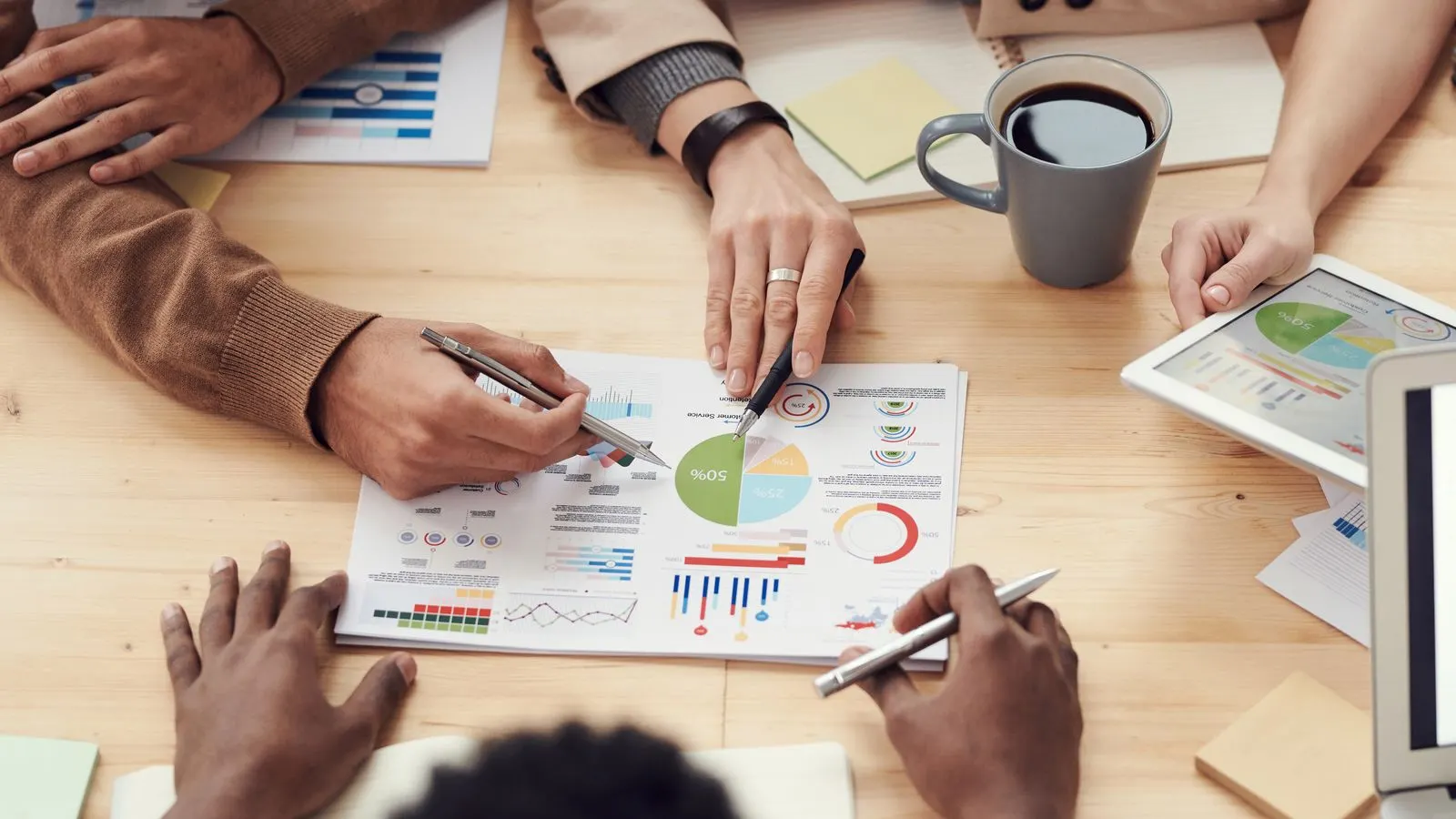 Team reviewing printed charts and notes around a bright conference table